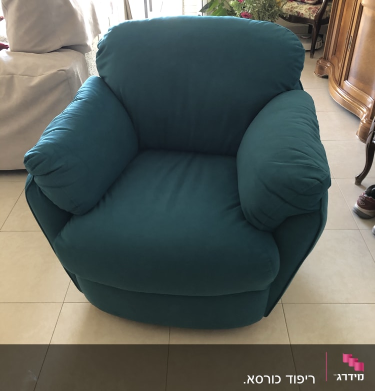 כורסה מרופדת בצבע טורקיז עם כריות צד